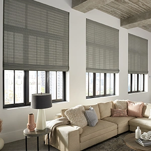Woven shades in a large living room area, with three large windows.